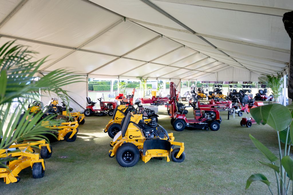 Cox ride-on mowers and outdoor equipment on display under a marquee at a product launch event