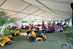 Cox ride-on mowers and outdoor equipment on display under a marquee at a product launch event